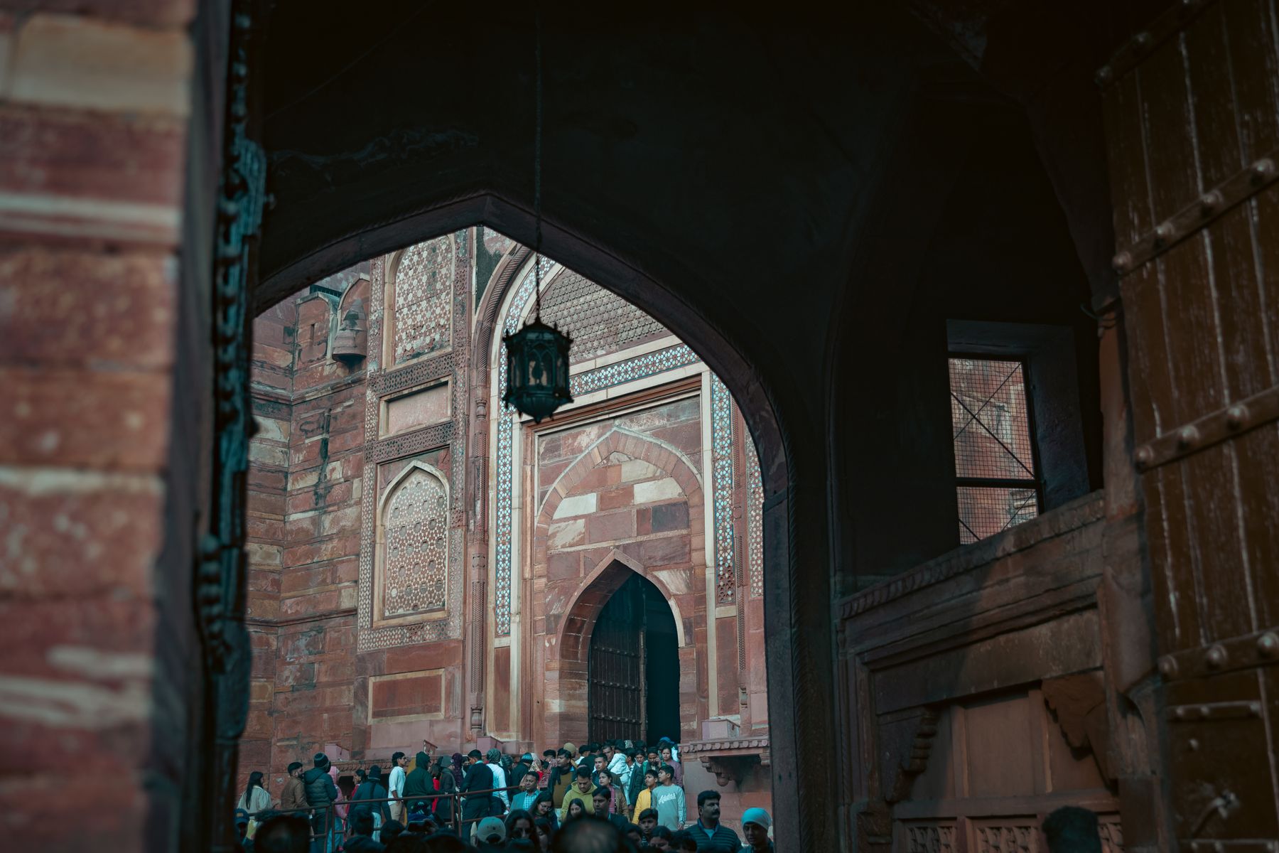 Crowd Framed By Red Sandstone Gateway